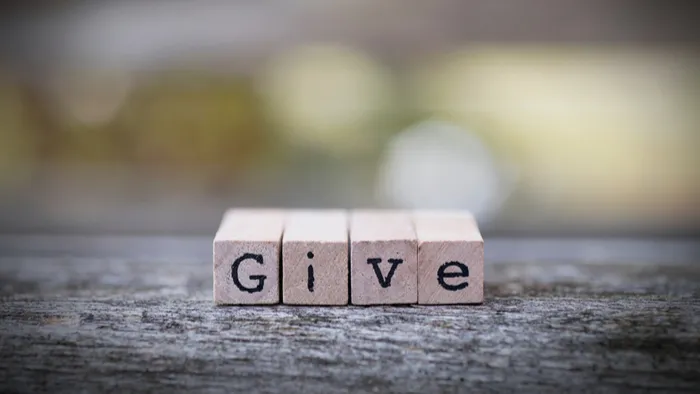 Wooden letter blocks spelling “Give”